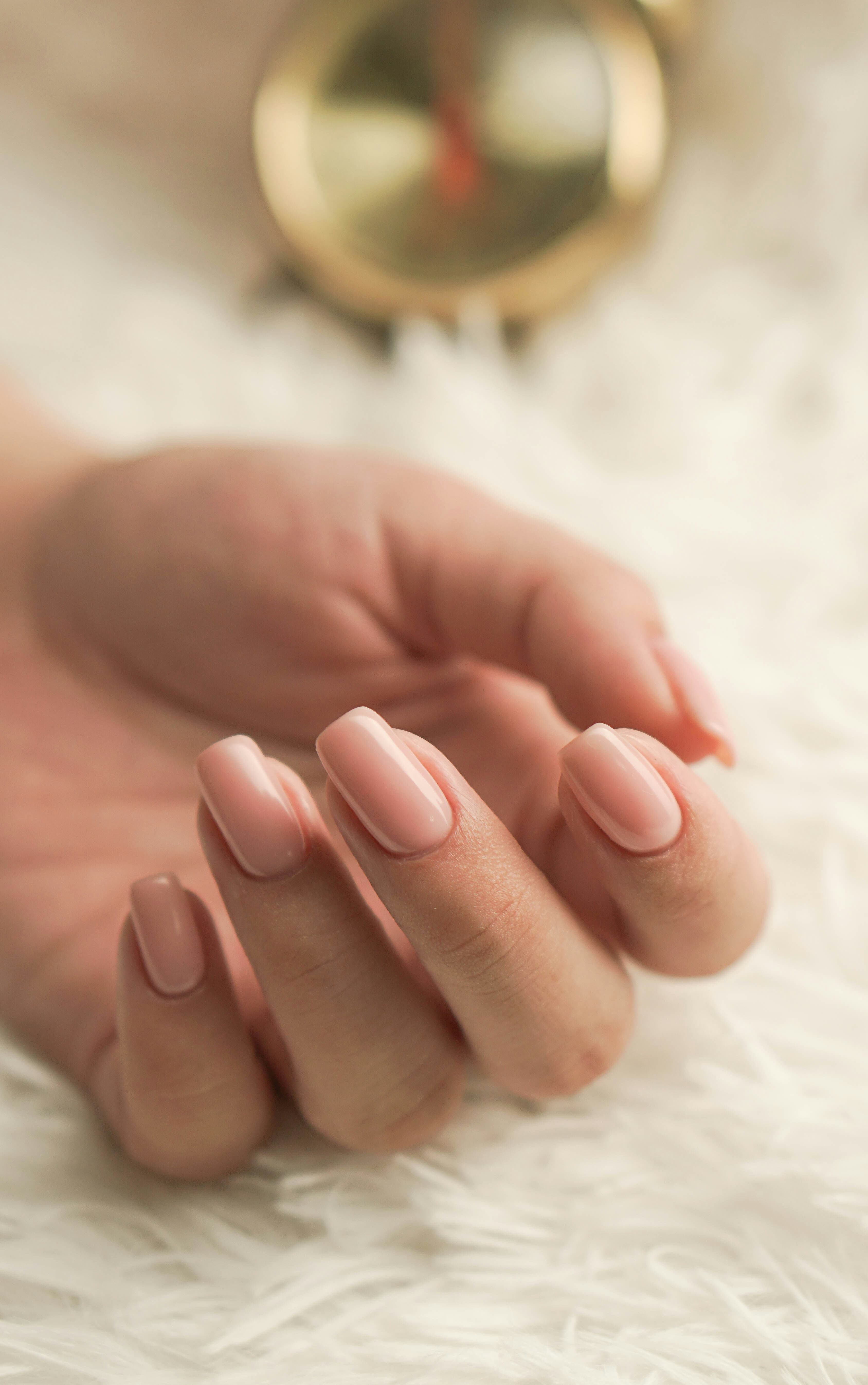 Manos con manicura en tono rosa claro